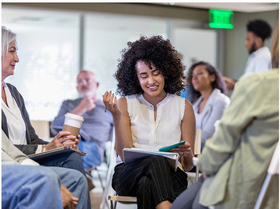 A group of people sitting around each other.