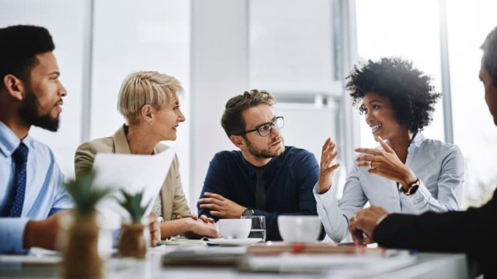 A group of people sitting around a table talking.